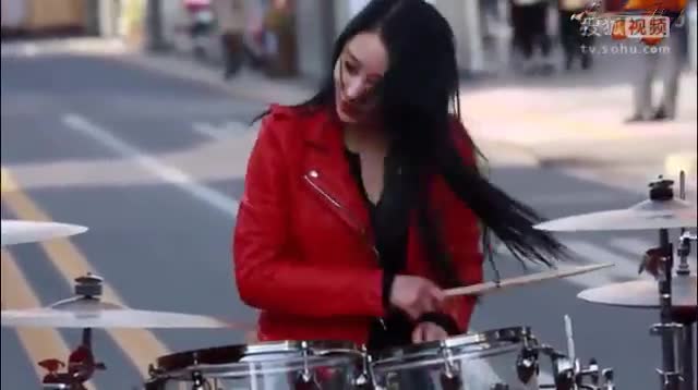 红衣女孩在大街上演奏架子鼓，很有水平