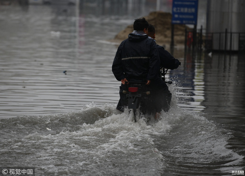 暴雨致哈尔滨道路积水 民众骑车出行如划船 第1页